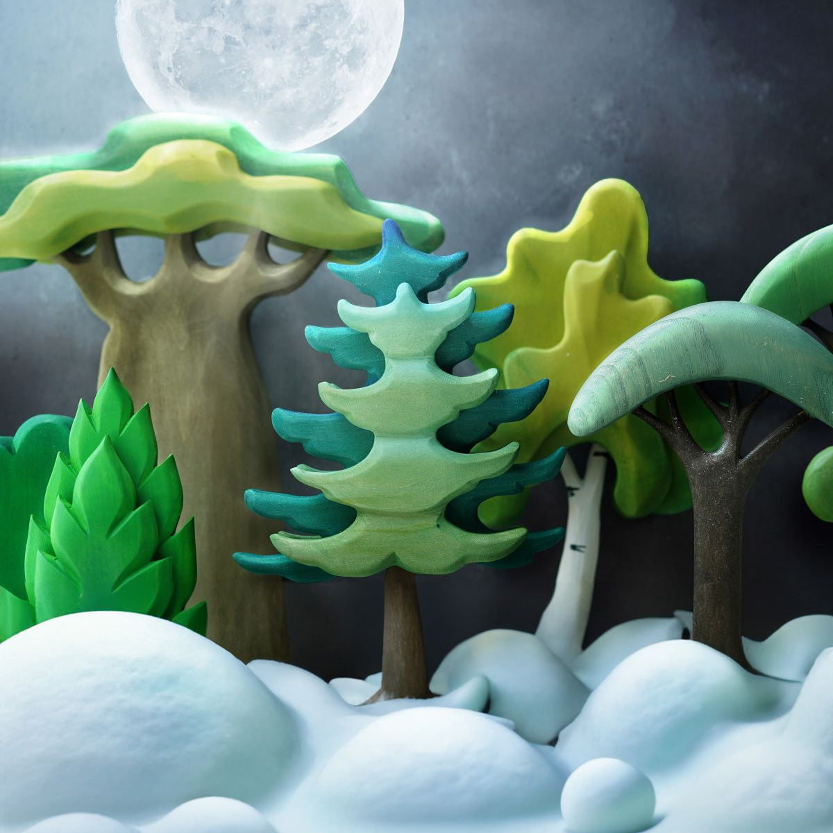 A cold, snowy winters scene with a mix of wooden toy trees and a full moon in the background