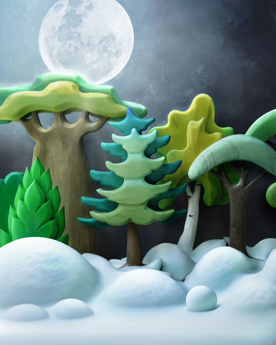 A cold, snowy winters scene with a mix of wooden toy trees and a full moon in the background