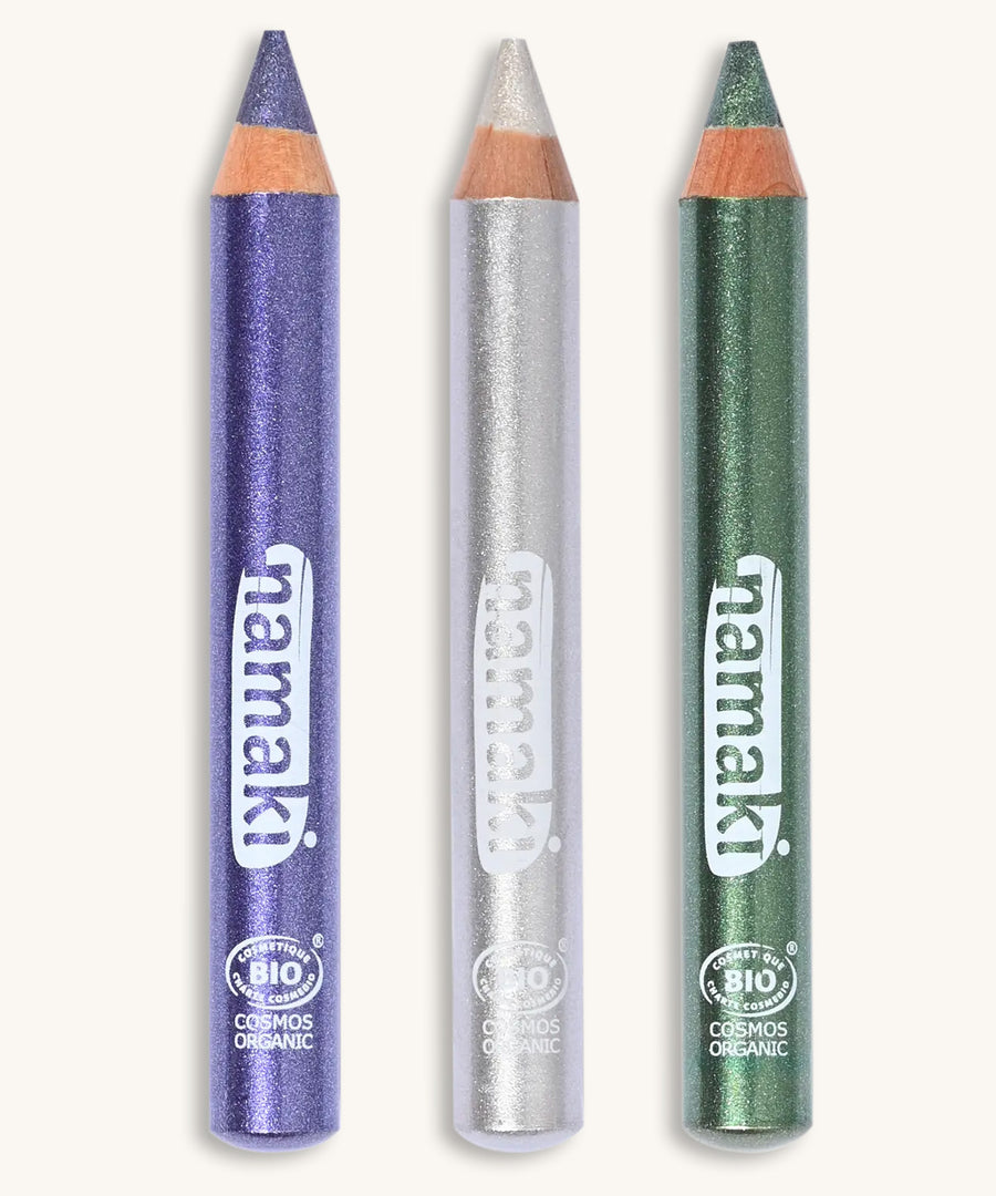 A green, silver and purple glitter make up pencil on a cream background