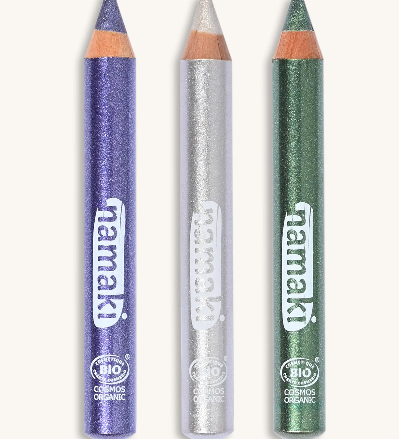 A green, silver and purple glitter make up pencil on a cream background