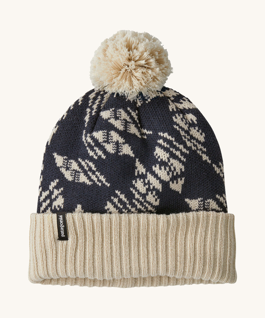 A blue and cream Patagonia bobble beanie with a cream pattern on a cream background. 