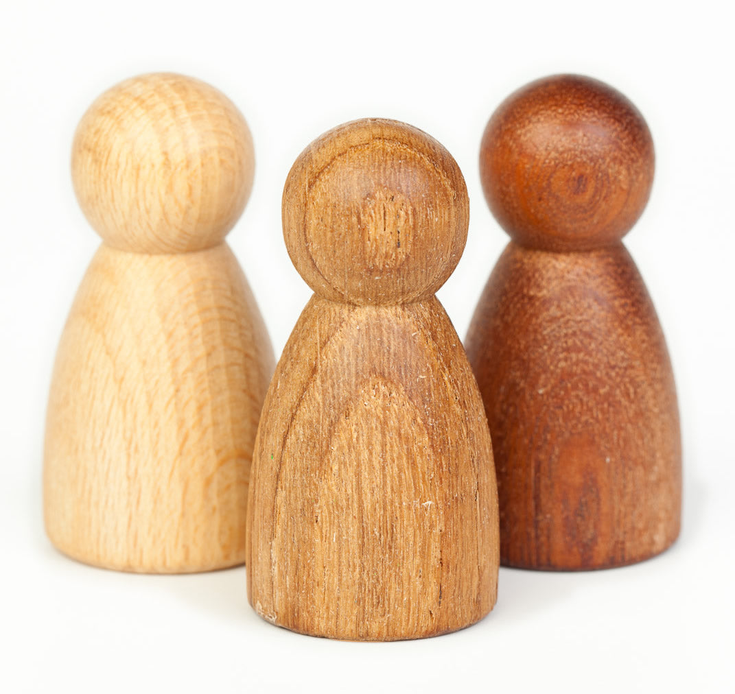 oak and sapeli wood with a natural oiled finish. Simple and tactile peg dolls for Waldorf story telling and small world play. Child paying with nins.