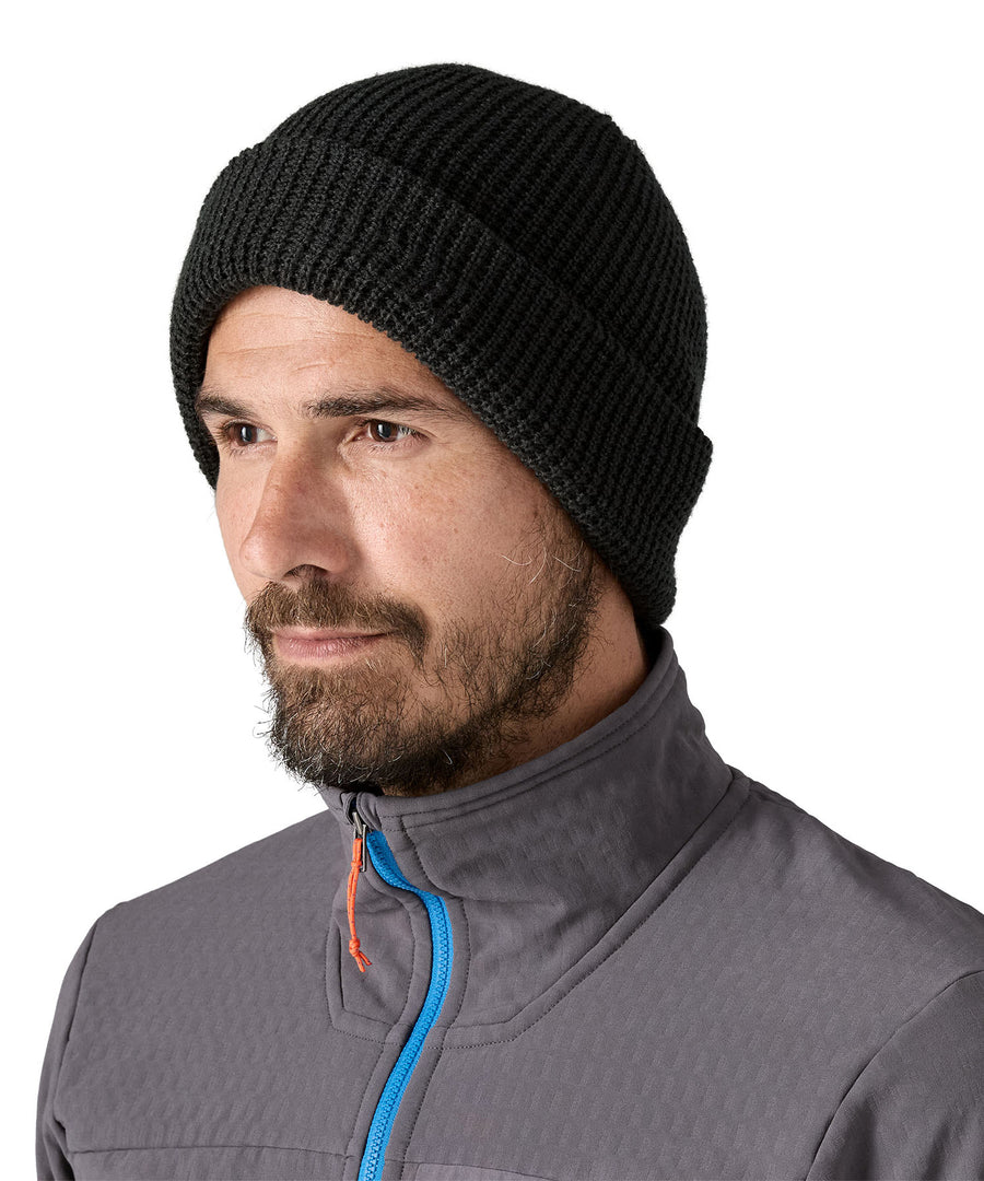 A male adult wearing the plain black Patagonia beanie.