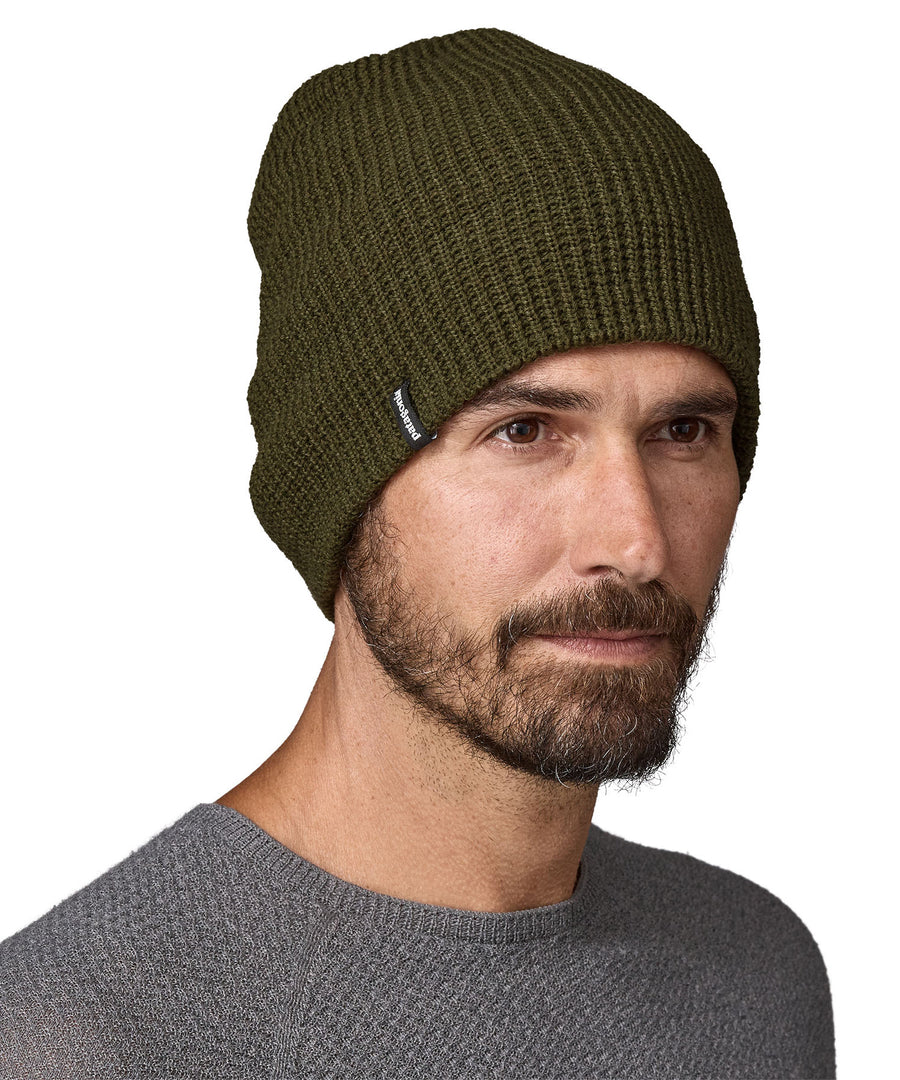 A side view of the dark green Patagonia beanie turned down