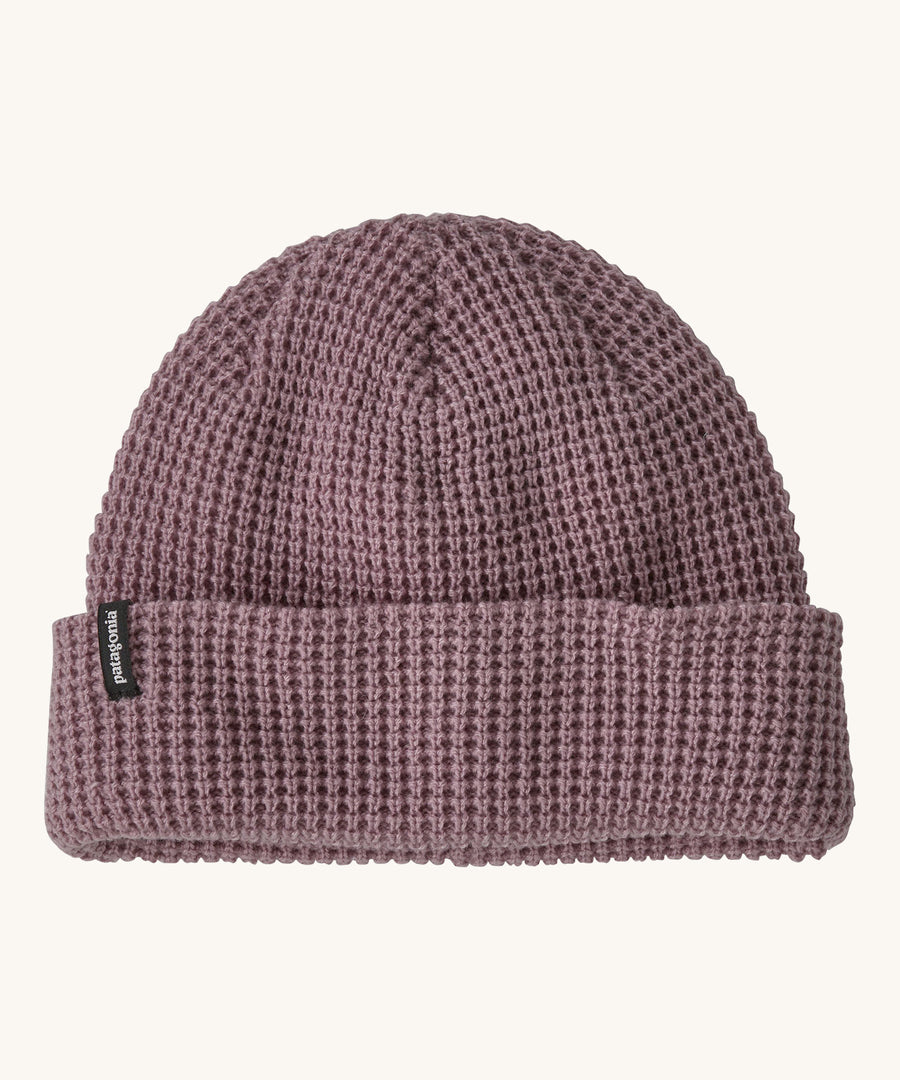 A plain light pink Patagonia beanie on a cream background