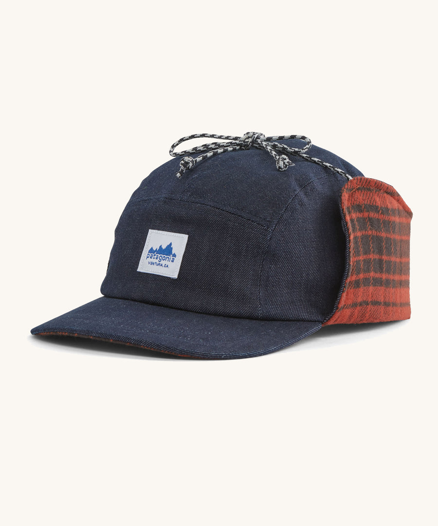 A blue Patagonia earflap cap with a check design on the inside