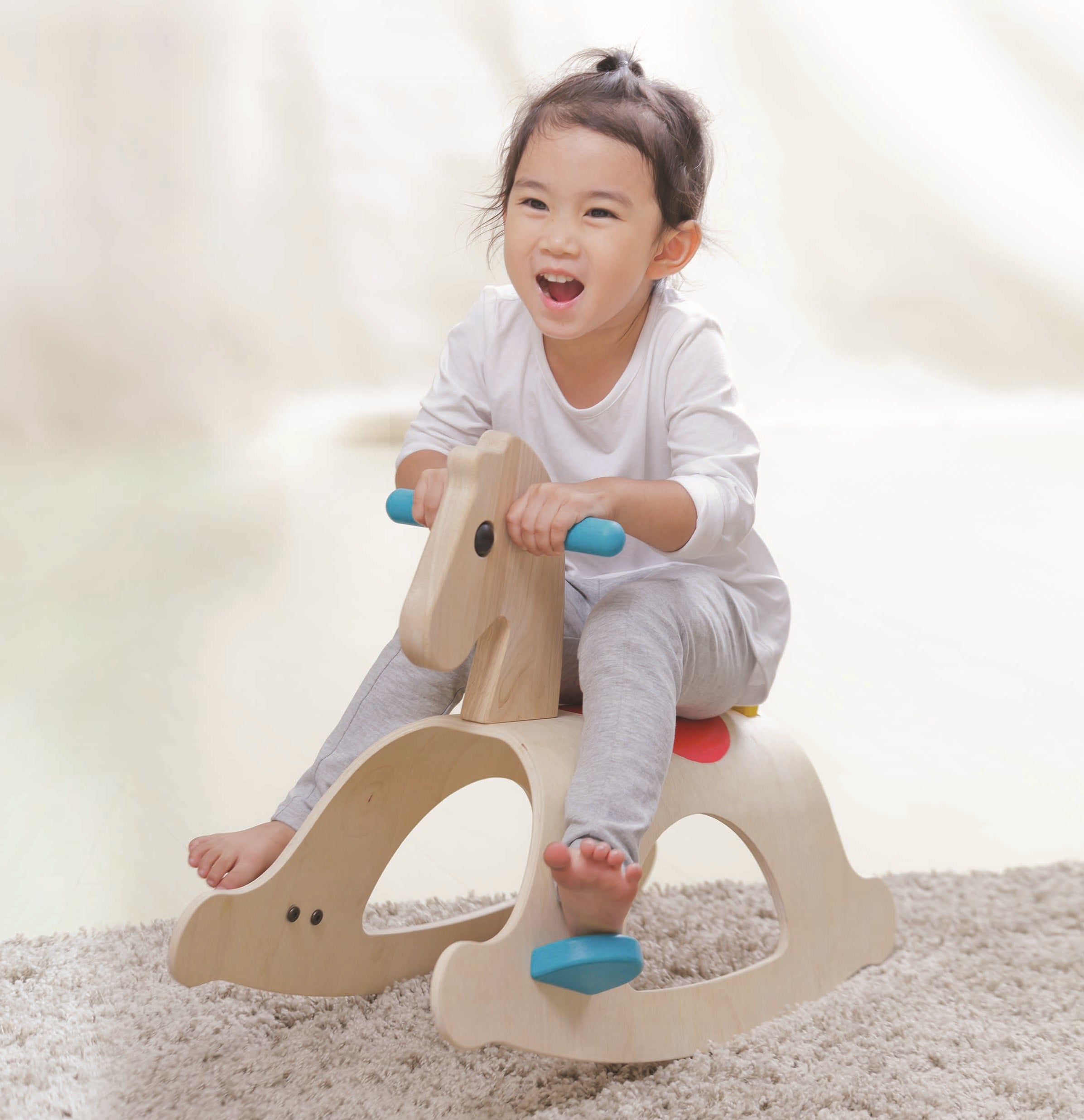 A child rocking on the PlanToys Palomino Rocking Horse. 