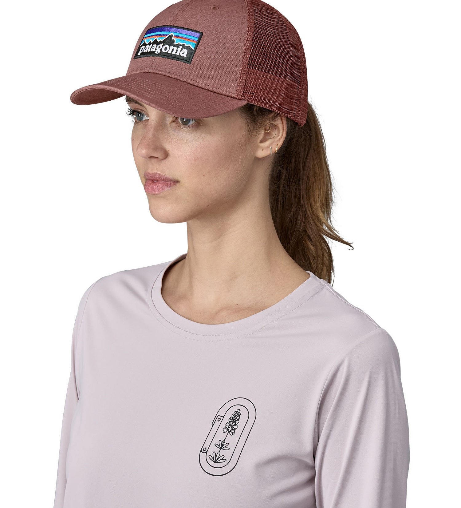 A female adult wearing the pink Patagonia trucker hat