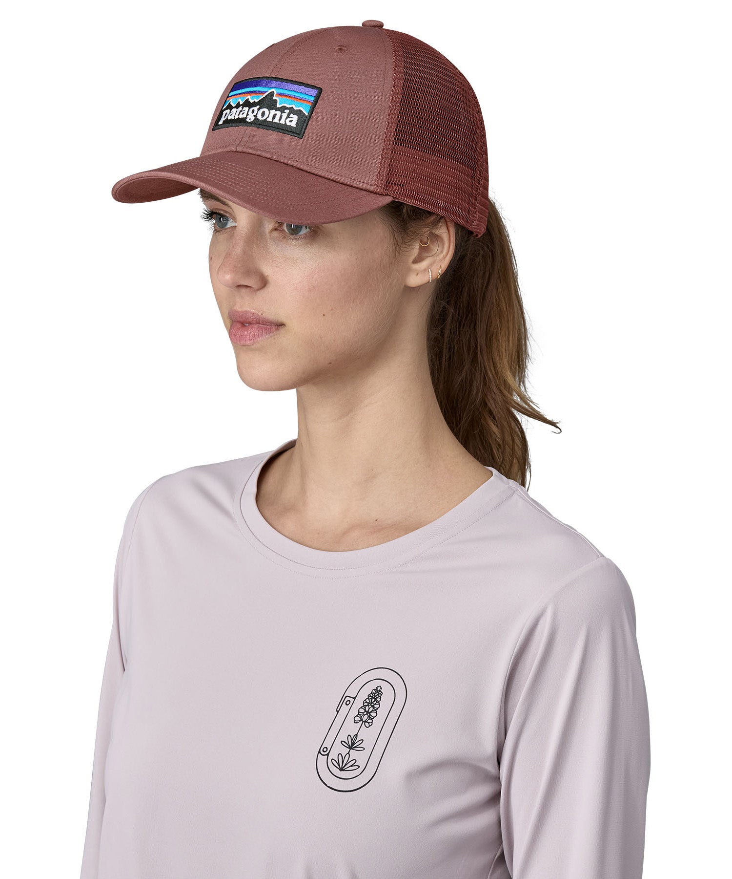 A female adult wearing the pink Patagonia trucker hat