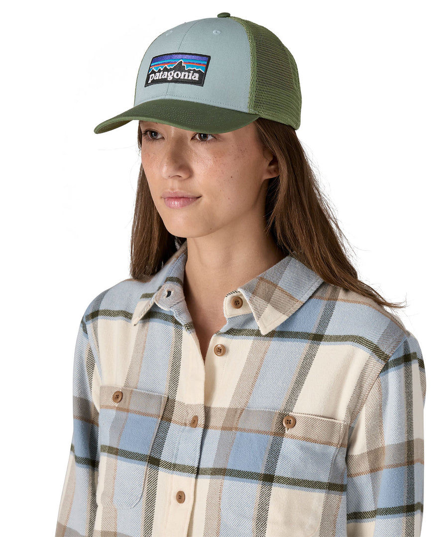 A female adult wearing the light blue and green Patagonia trucker hat