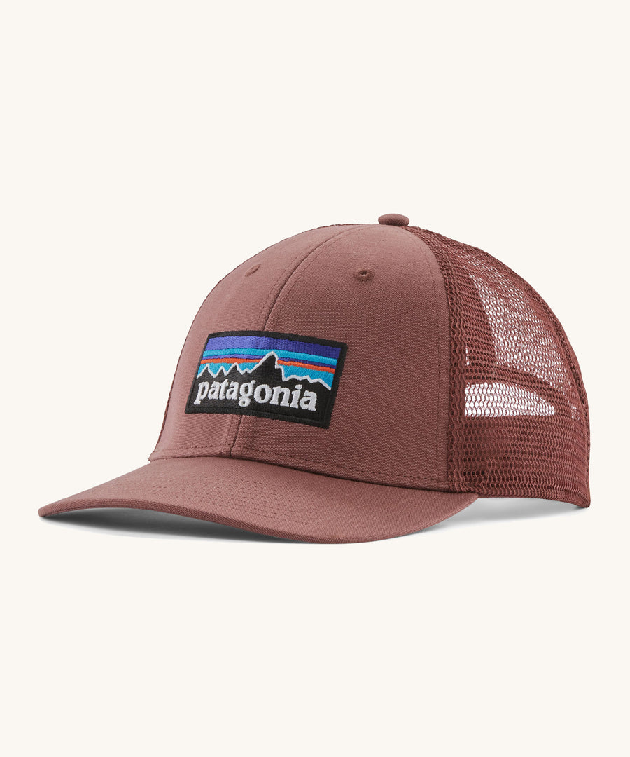 A pink Patagonia trucker hat with the Patagonia logo on the front on a cream background