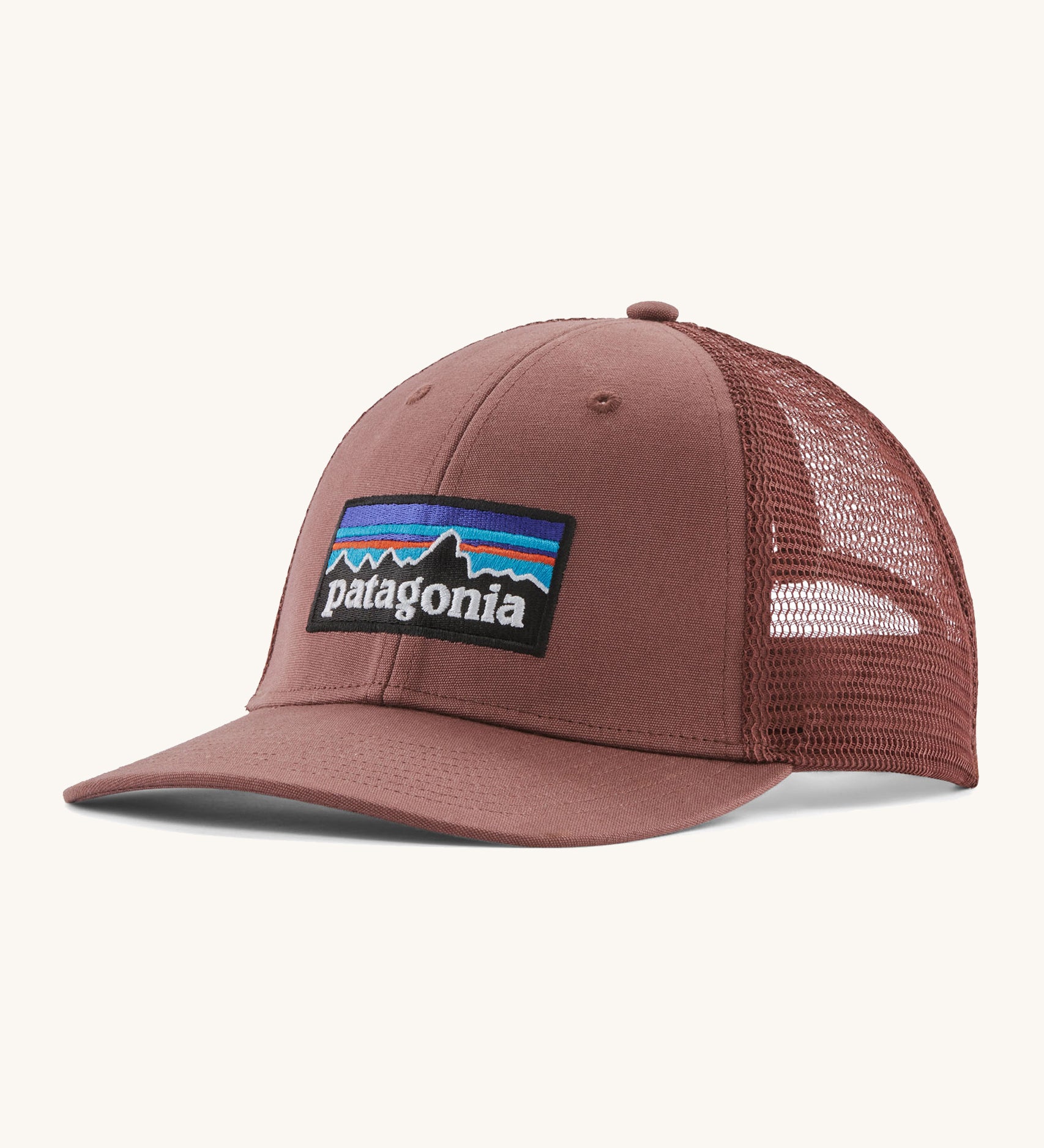 A pink Patagonia trucker hat with the Patagonia logo on the front on a cream background