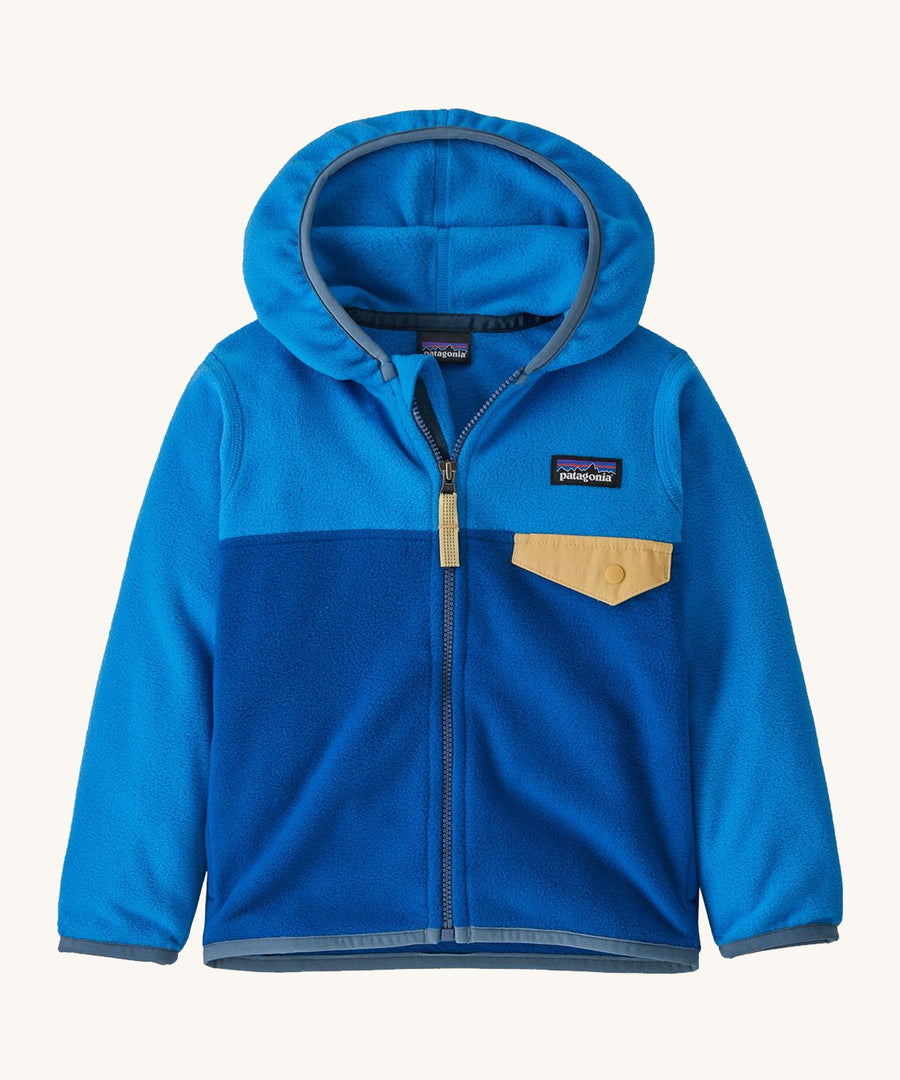 Blue kids Patagonia fleece with a gold pocket on a cream background