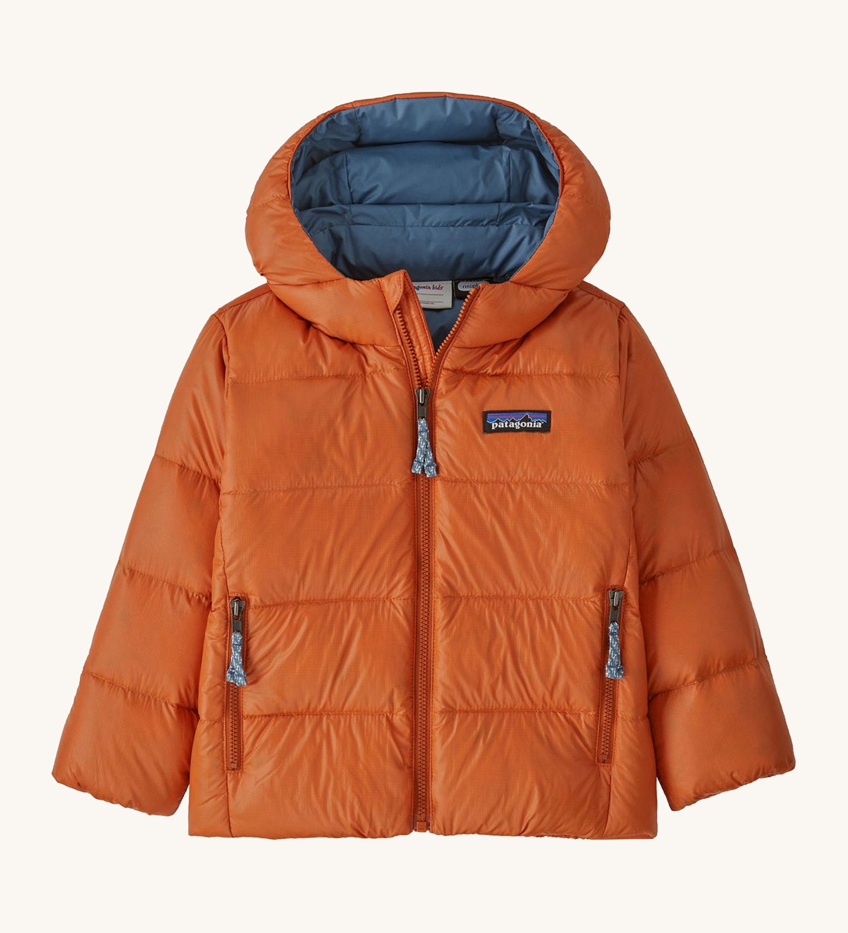 Orange kids Patagonia down jacket on a cream background