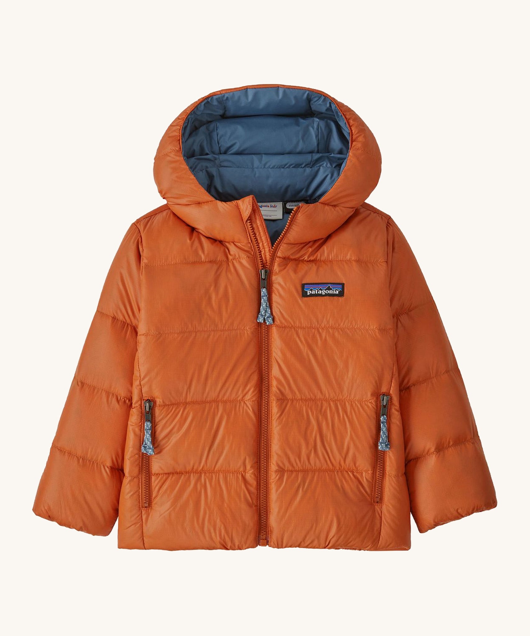 Orange kids Patagonia down jacket on a cream background