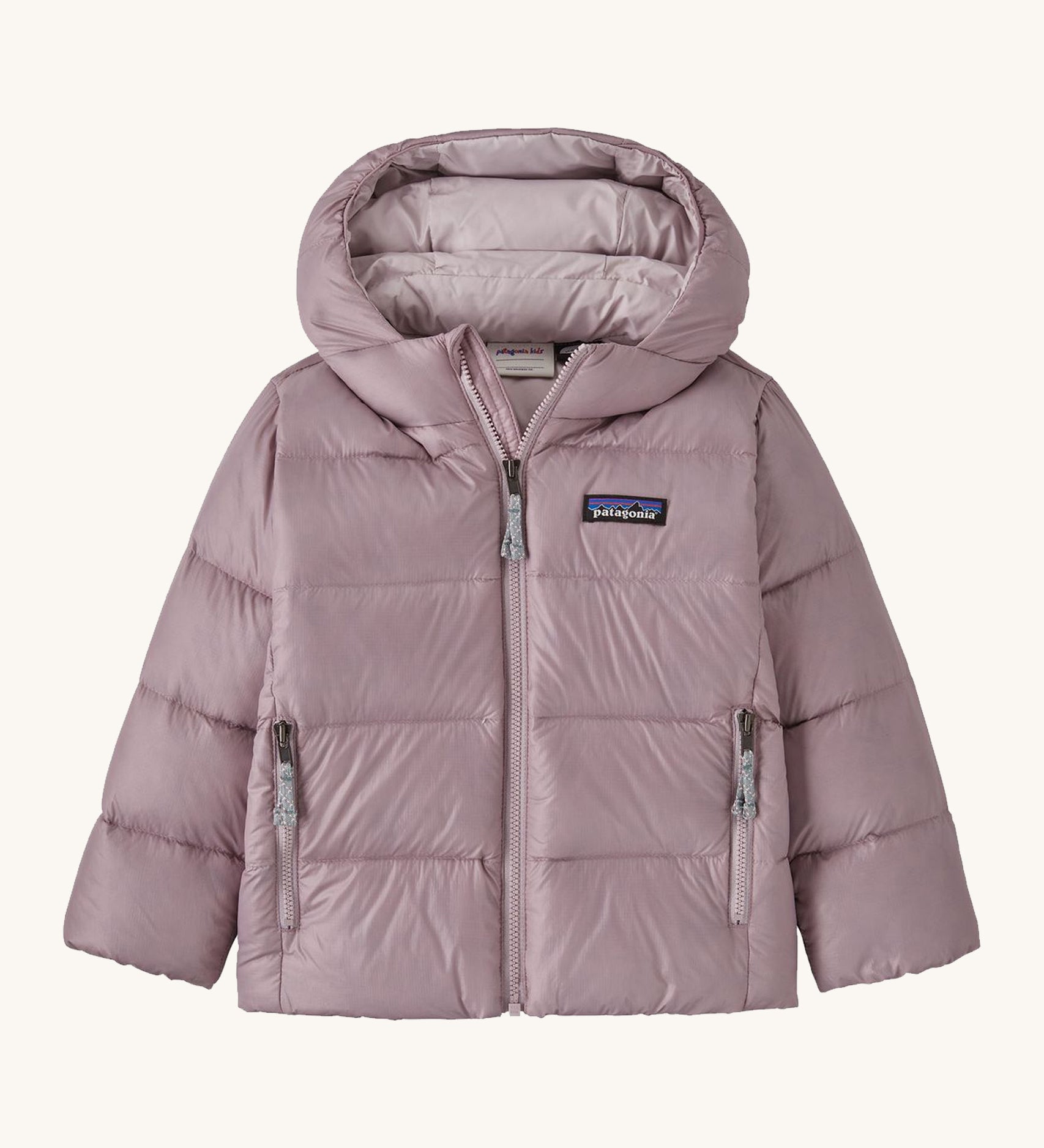 Light pink kids Patagonia down jacket on a cream background