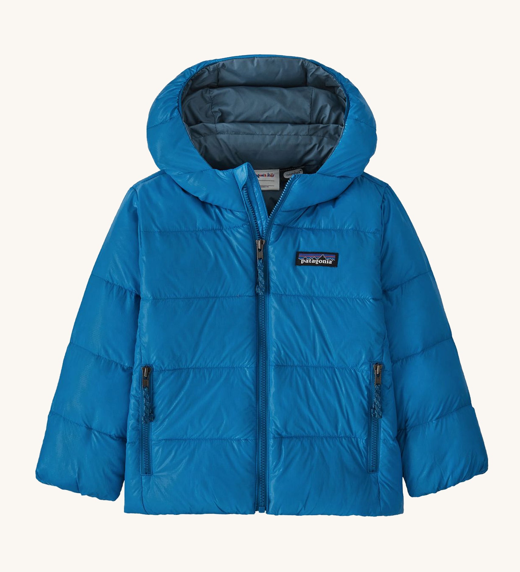 Light blue kids Patagonia down jacket on a cream background