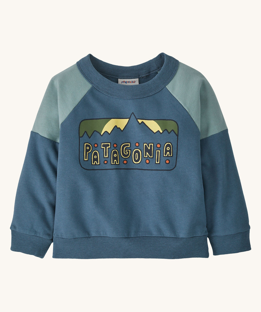 Blue baby sweatshirt with the Patagonia logo on the front on a cream background