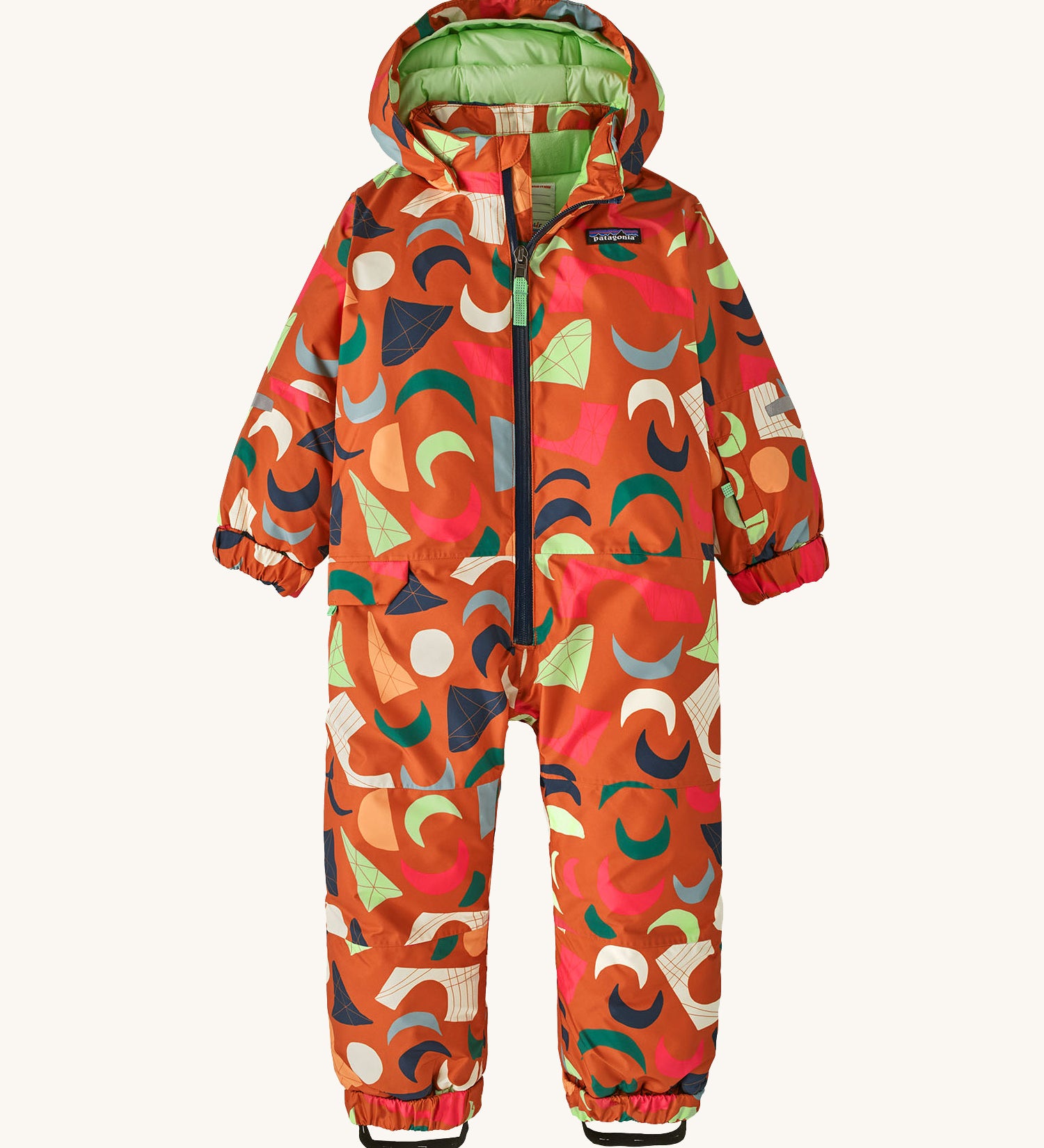 A orange all in one snowsuit with different coloured shapes on a cream background