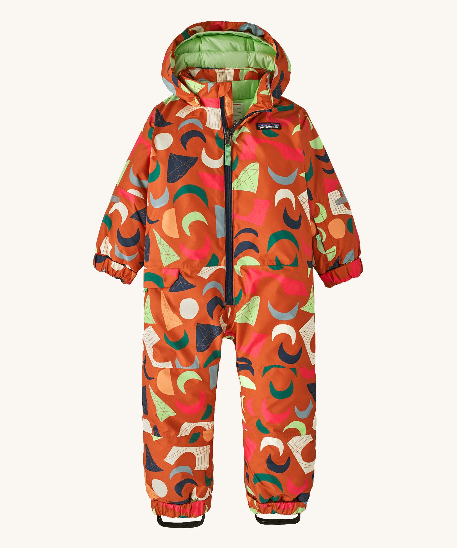 A orange all in one snowsuit with different coloured shapes on a cream background