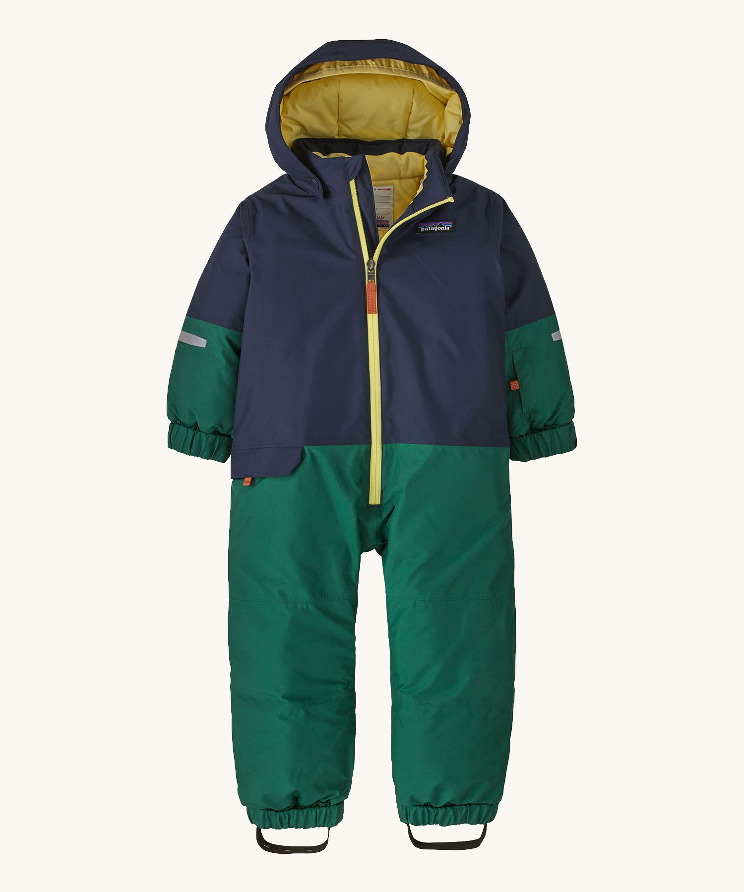 A navy and green hooded all in one snowsuit on a cream background.