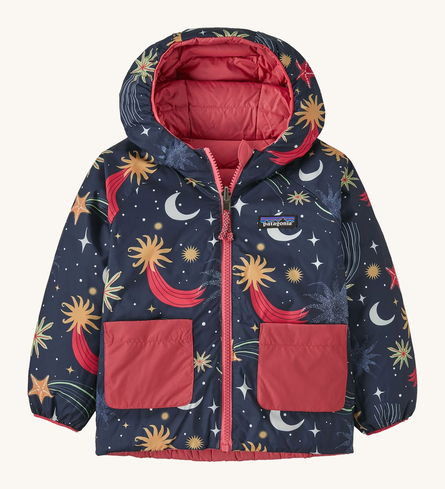 Navy Patagonia reversible jacket with a moon and stars design and red pockets on a cream background