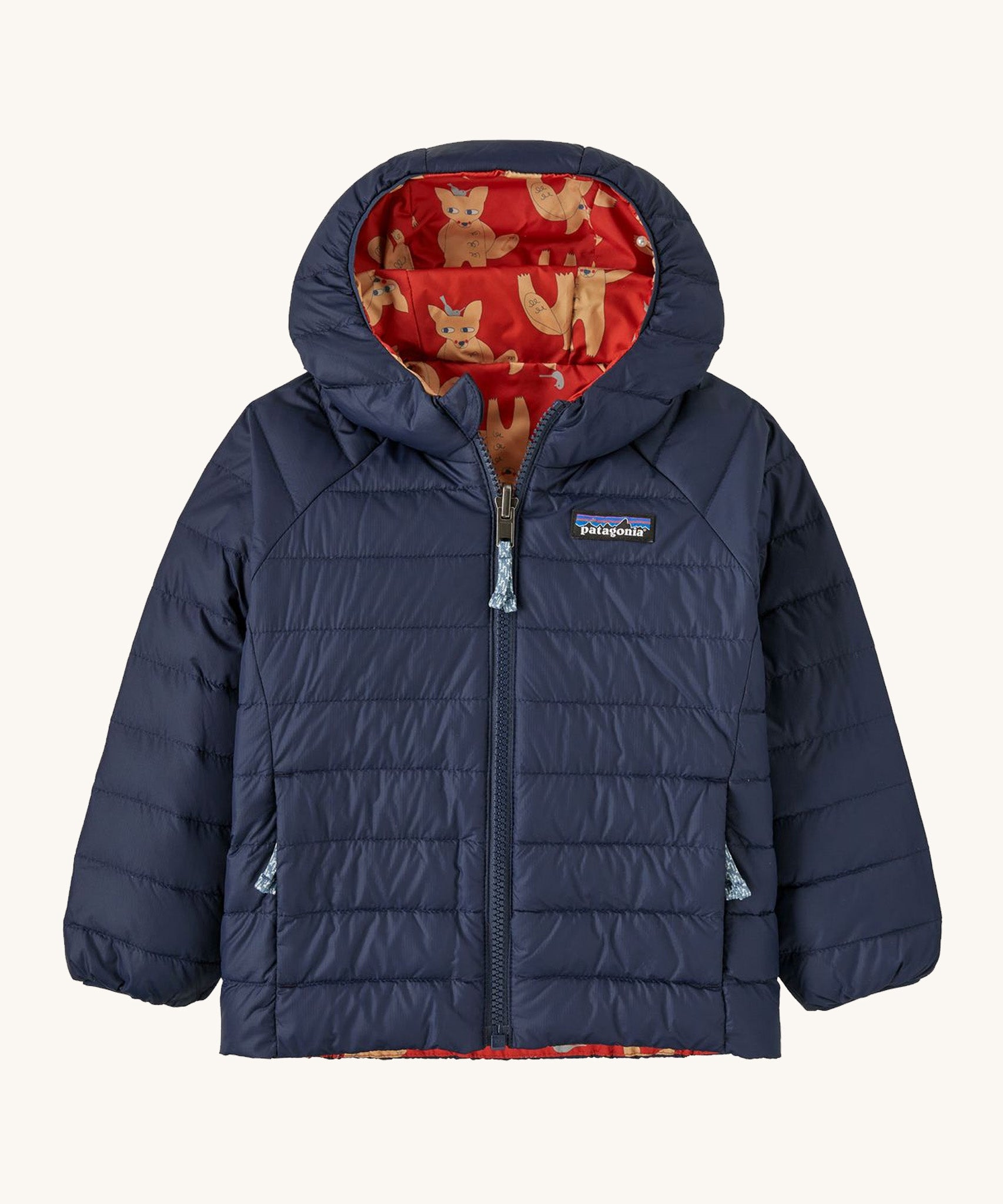 Navy Patagonia jacket with a fox reversible print on the inside on a cream background