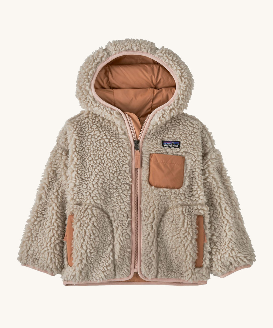 Natural kids Patagonia fleece with a light pink trim on a cream background