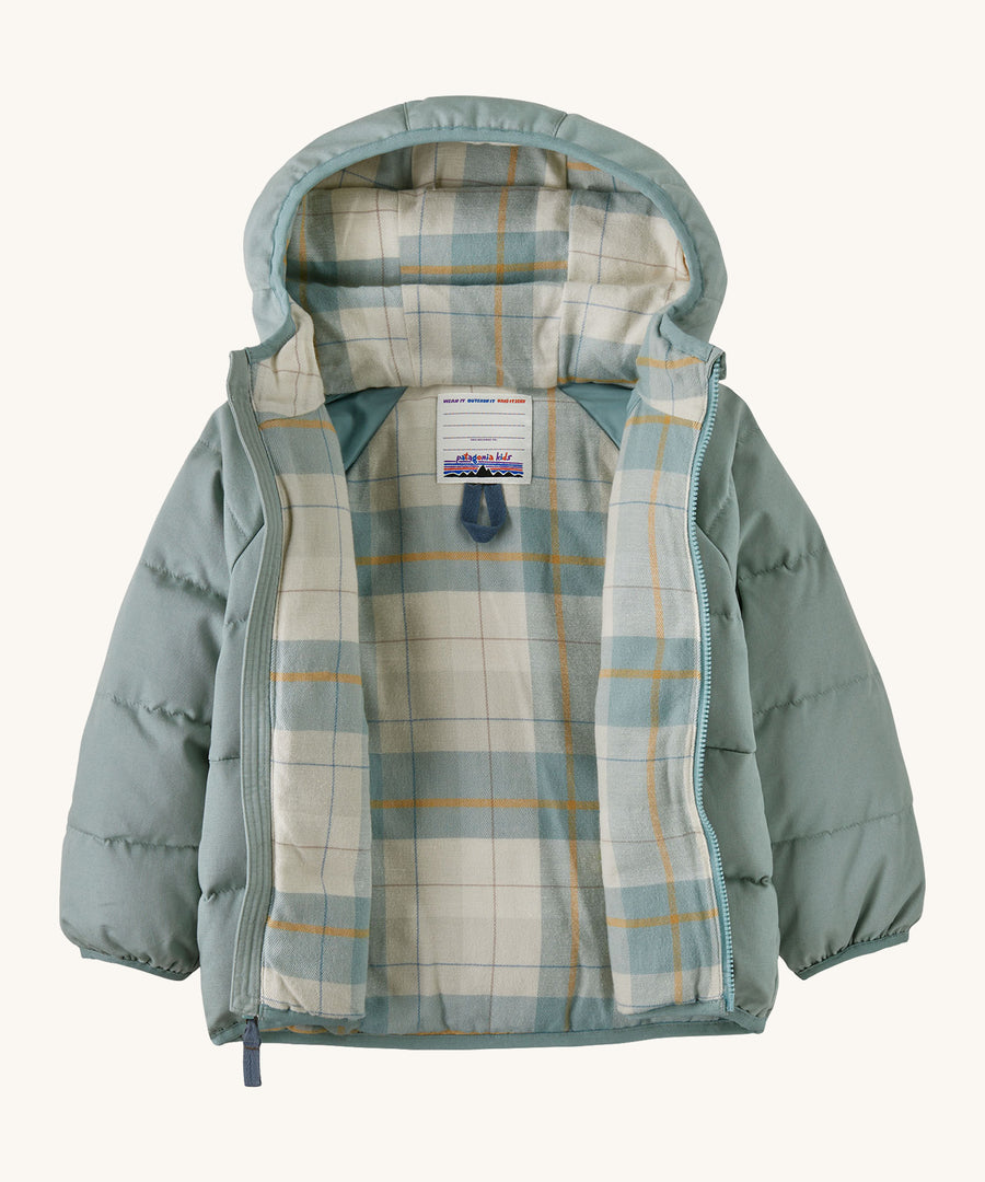 A light blue hooded opened jacket with a check design on the inside on a cream background