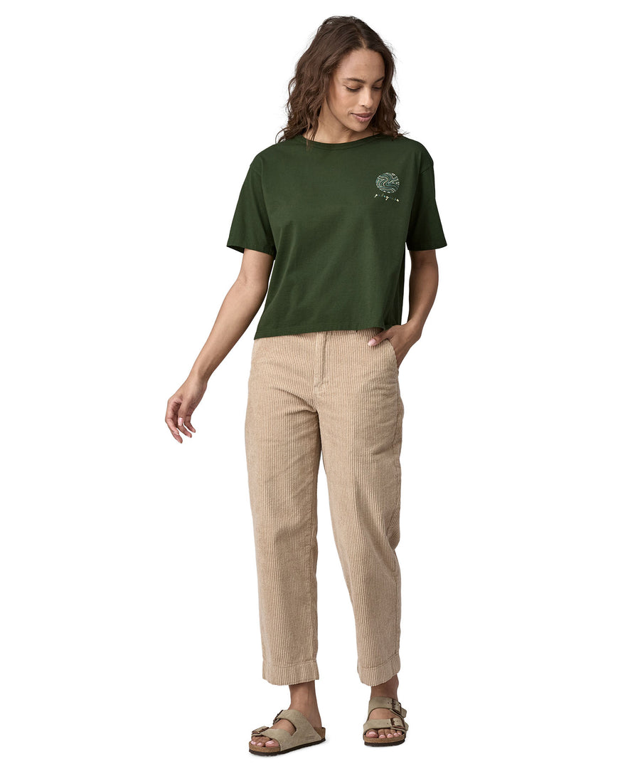 An adult wearing the Patagonia Women's Easy Cut Organic T-Shirt - Pine Green. The image shows a small earth logo on the front of the chest