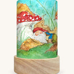 The Autumn Gnome illustration by Eentje Van Margo sat in a Toverlux Magic Lantern base, on a cream background