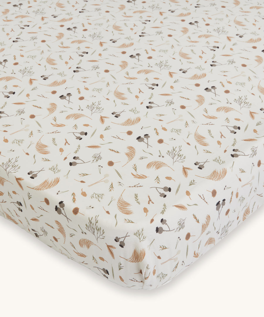 Avery Row Cotbed Fitted Sheet - Grasslands. A light cream fitted sheet with delicate grassland print