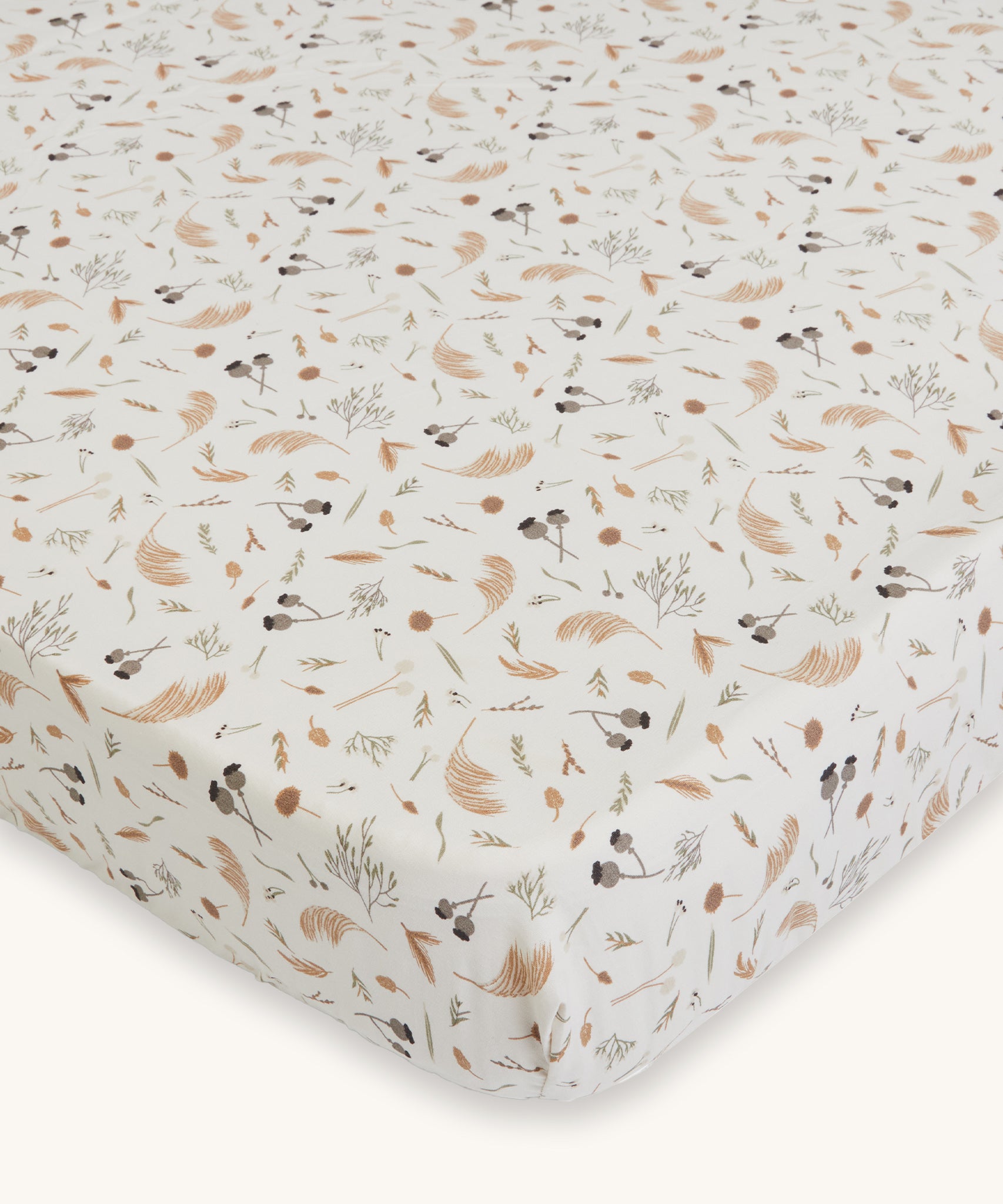 Avery Row Cotbed Fitted Sheet - Grasslands. A light cream fitted sheet with delicate grassland print