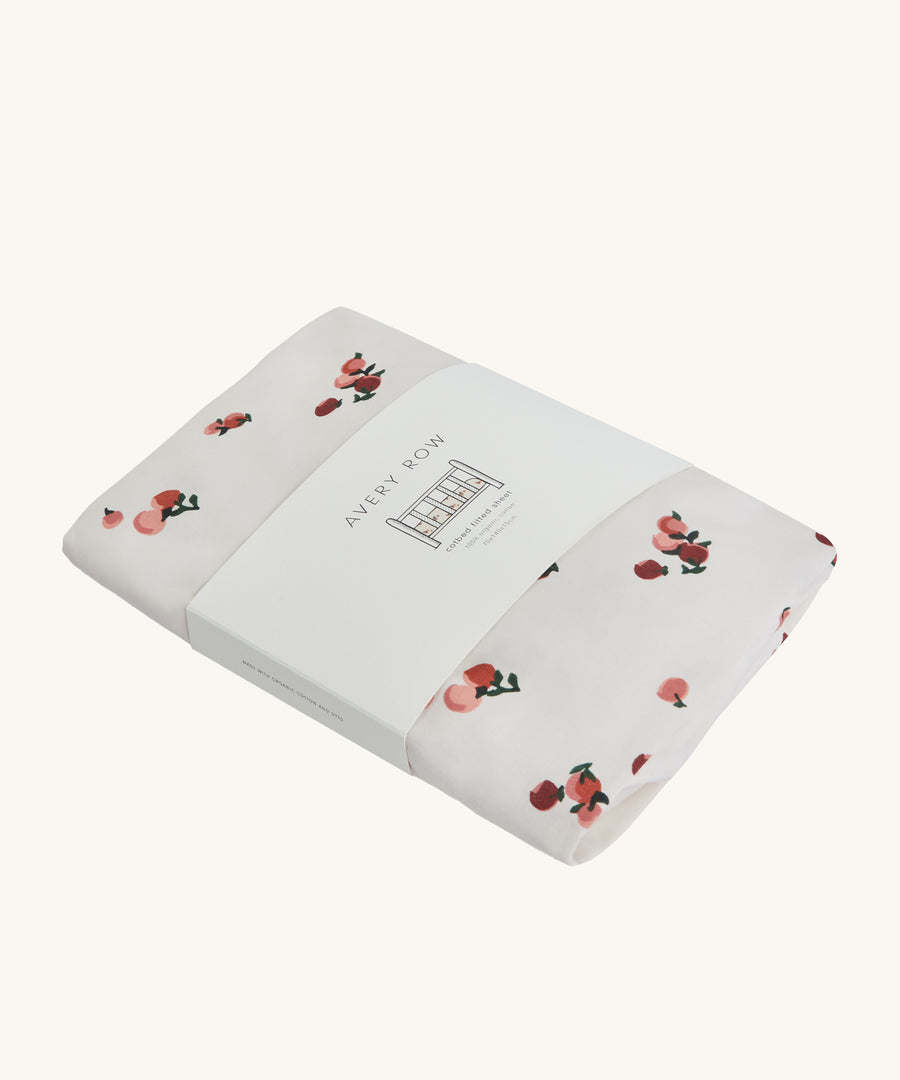 Avery Row Cotbed Fitted Sheet - Peaches on a plain background