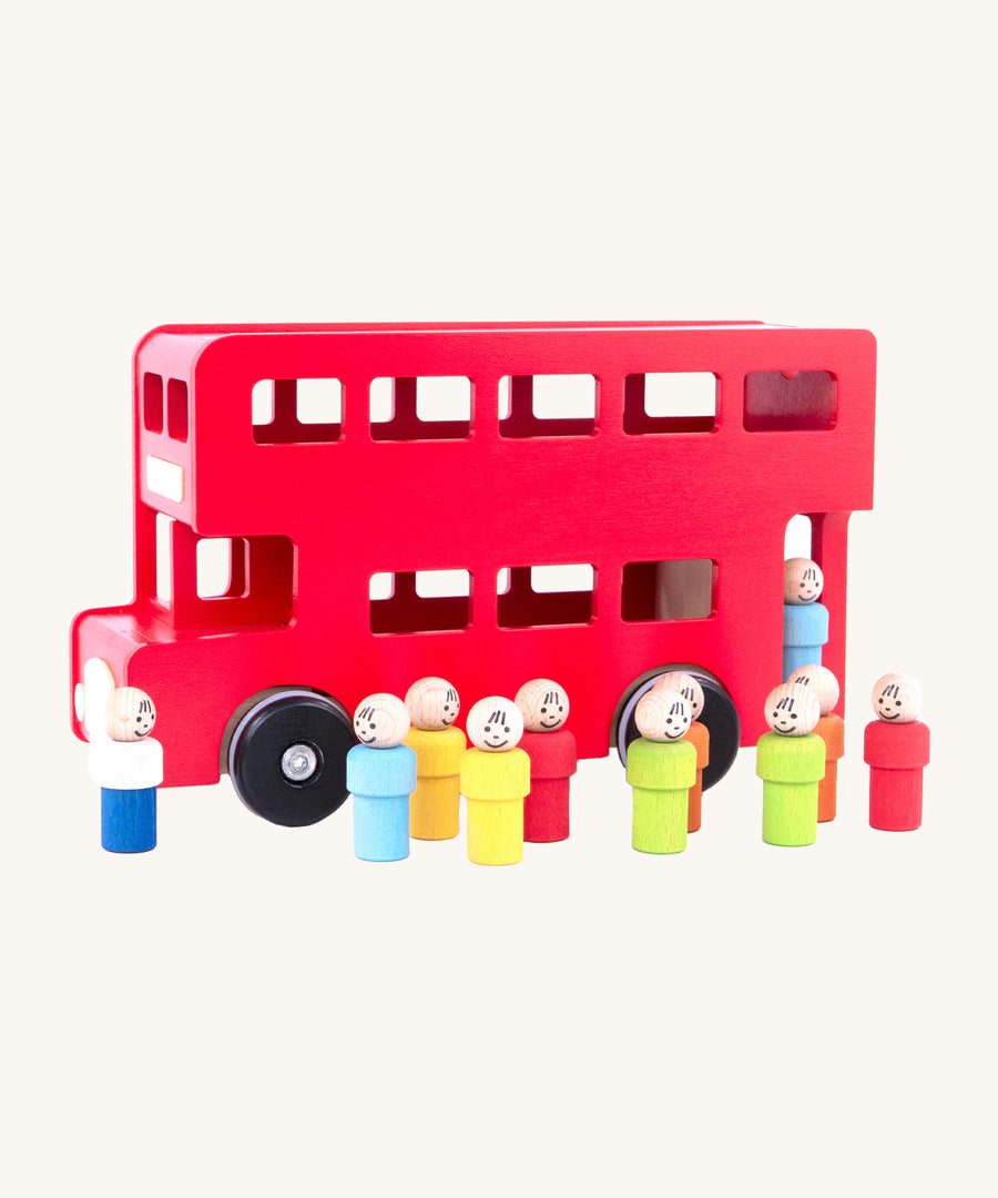 A the wooden peg doll passengers and drivers are outside the red London bus, on a cream background