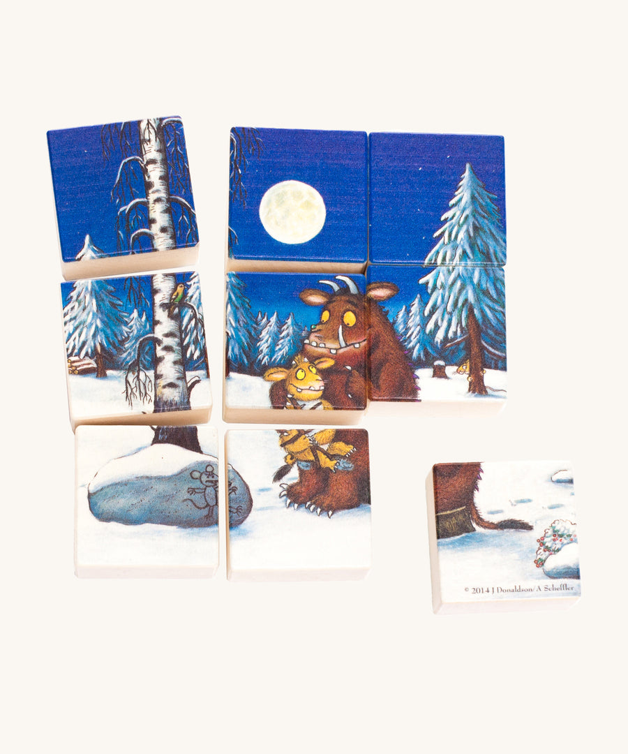 A winter scene of the Bajo Double Sided Puzzle Blocks, showing the Gruffalo with a baby Gruffalo, a snowy woodland, a navy blue sky and a full moon