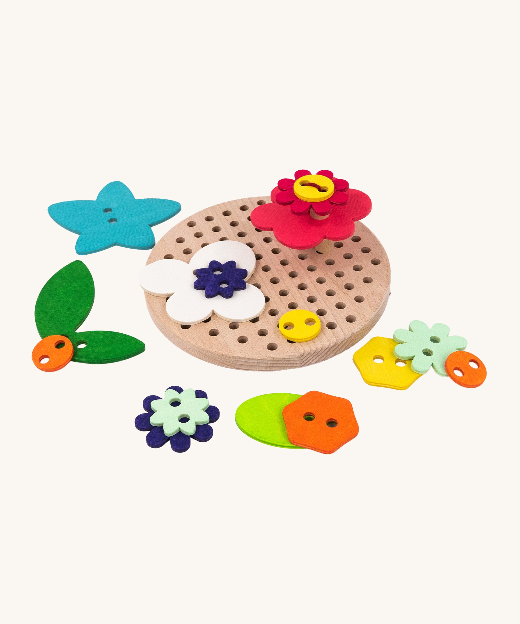 The A top down view of the Bajo Wooden Lacing Toy - Flower Meadow. The image shows different shaped wooden flowers disks, next to the wooden board with holes. The image is on a cream background