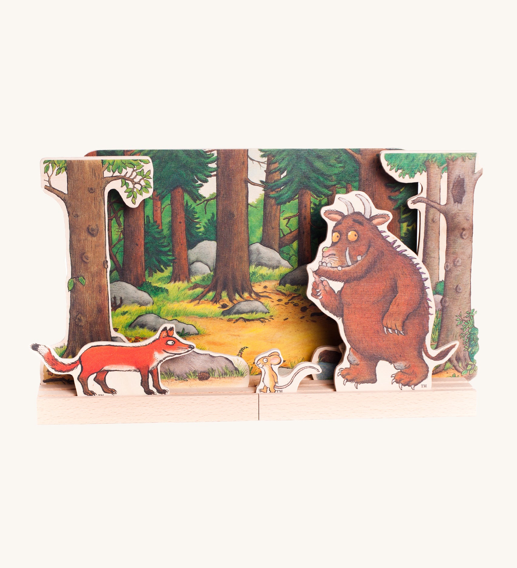 Bajo Gruffalo Wooden Theatre showing the woodland backdrop, Gruffalo, Muse and Fox characters set inside wooden boards with small grooves to hold the figures in place. The image is on a cream background