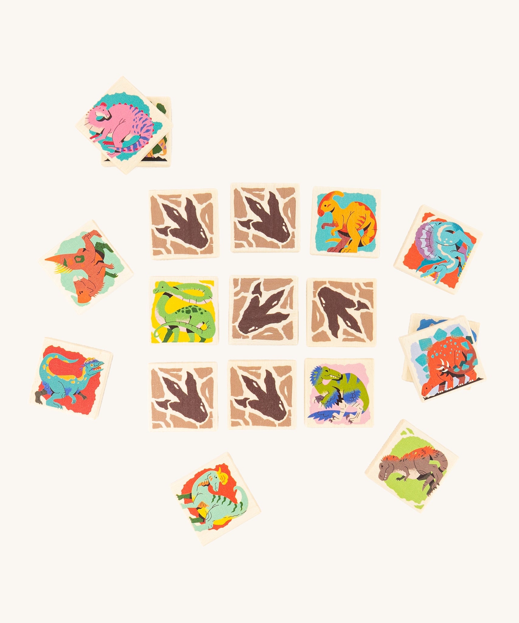 The Bajo Dinosaur Memory Game Toy showing square pieces with dinosaur pictures and dinosaur feet in a row of 3 by 3, with scattered dinosaur blocks surrounding the rows. 