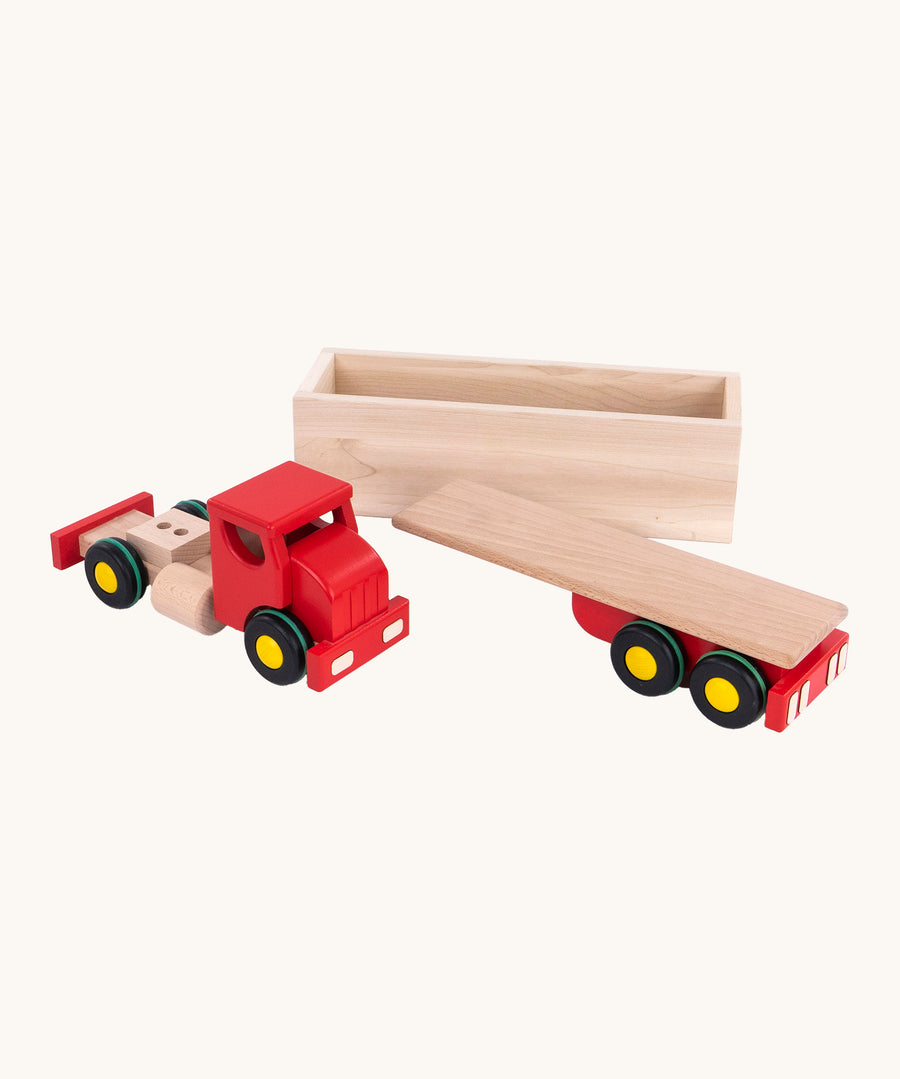 The Bajo Large Truck & Trailer in its 3 parts of one wooden cab, one wooden box trailer and one wooden base for the box trailer to attach on to. The image is on a cream background