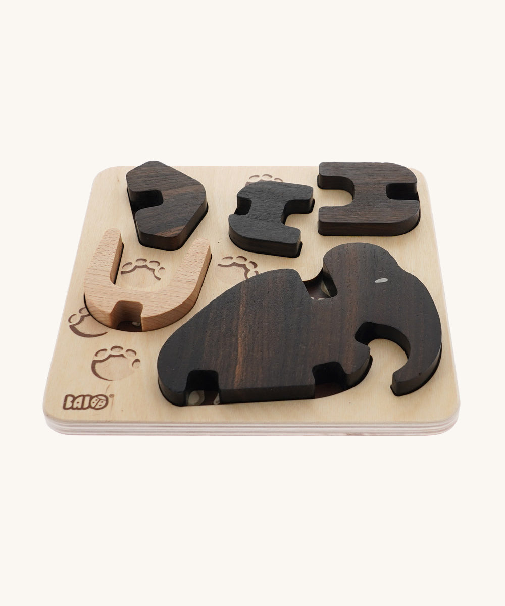 The Bajo Puzzle & Sorter - Black Oak Mammoth, showing the wooden mammoth pieces inside the wooden puzzle board on a cream background