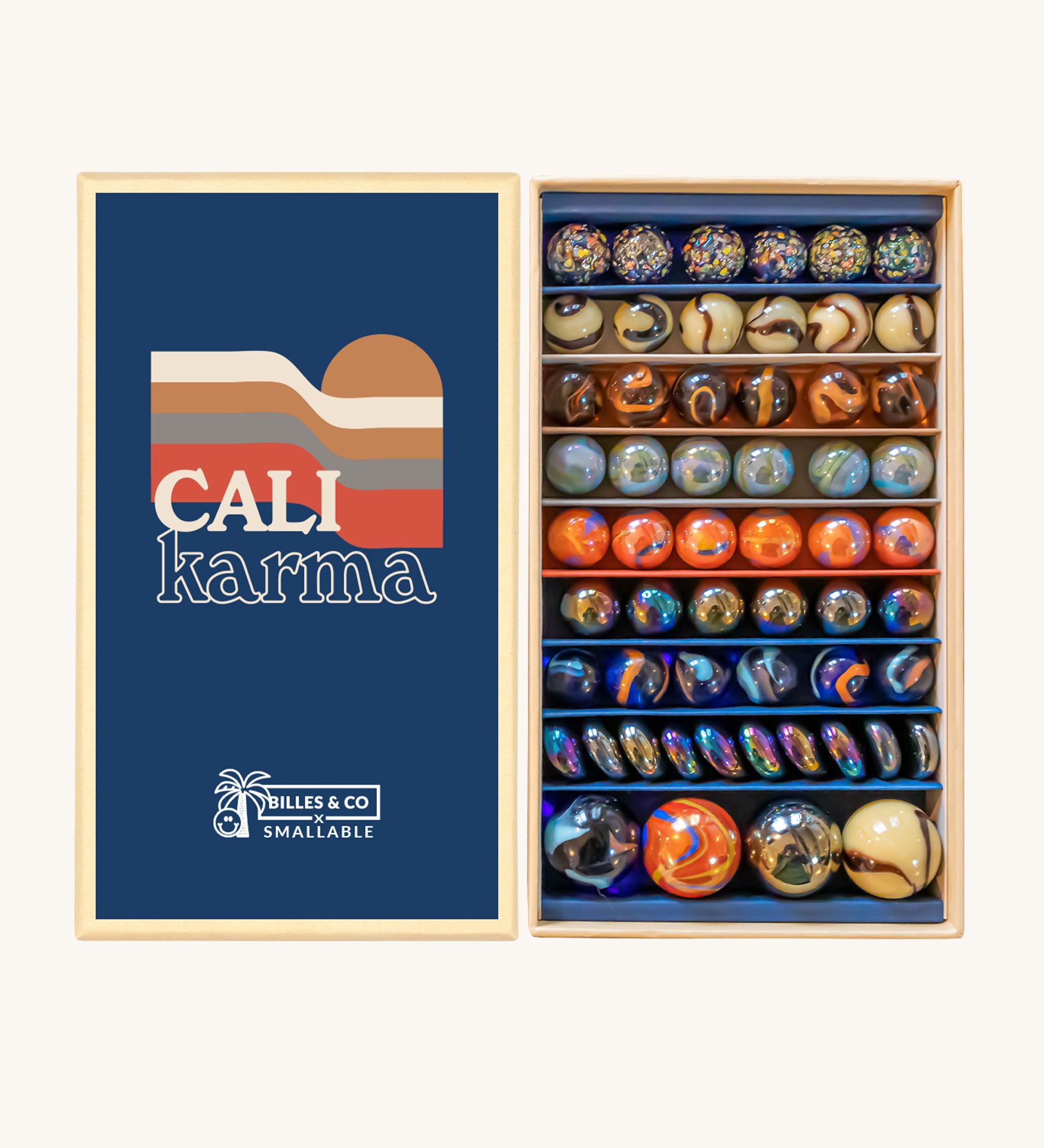 Billes & Co Cali Karma Marbles Box - 56 Pack. A selection of round and flat marbles in various shades of orange, grey, brown, beige and metallic