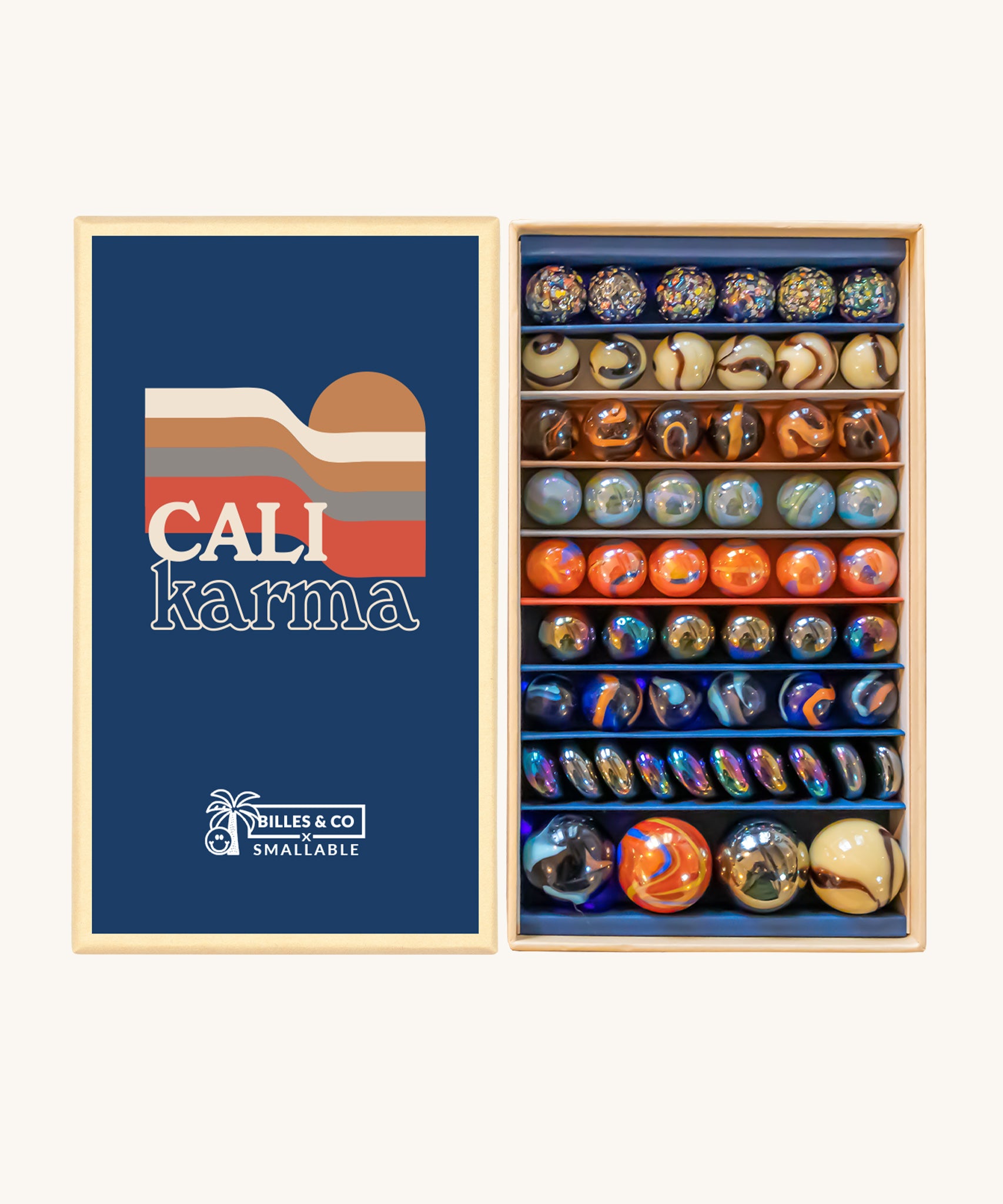 Billes & Co Cali Karma Marbles Box - 56 Pack. A selection of round and flat marbles in various shades of orange, grey, brown, beige and metallic