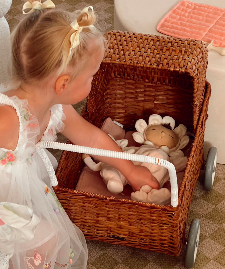 The light cream dinkum dolls lying down in the Olli Ella strolley