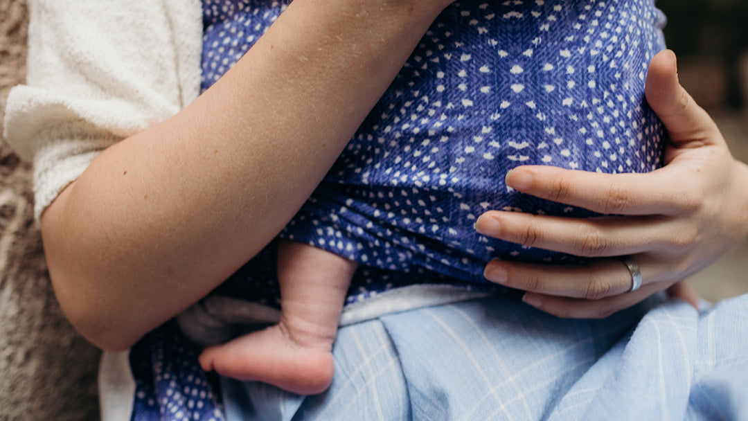 Closeup of a mother carrying her newborn in a Boba baby carrier