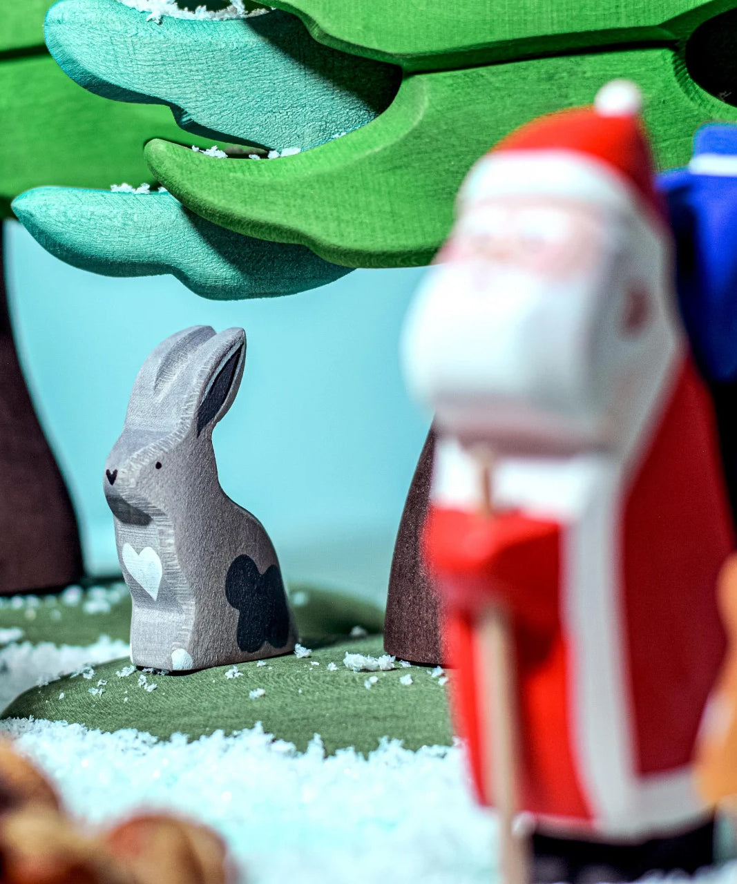 A Bumbu grey hare figure is sat under a tree, with the Bumbu Santa in the foreground. The Santa figure is blurry as the hare figure is in focus