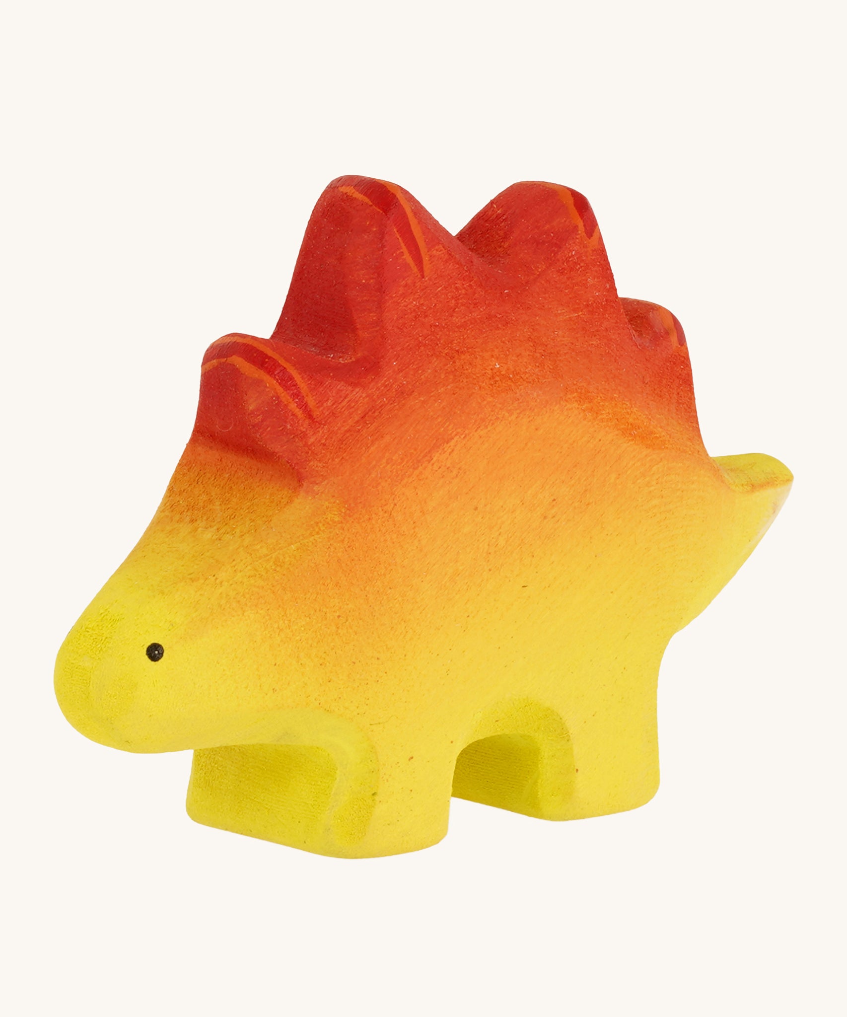 Bumbo wooden baby stegosaurus toy figure on a plain background