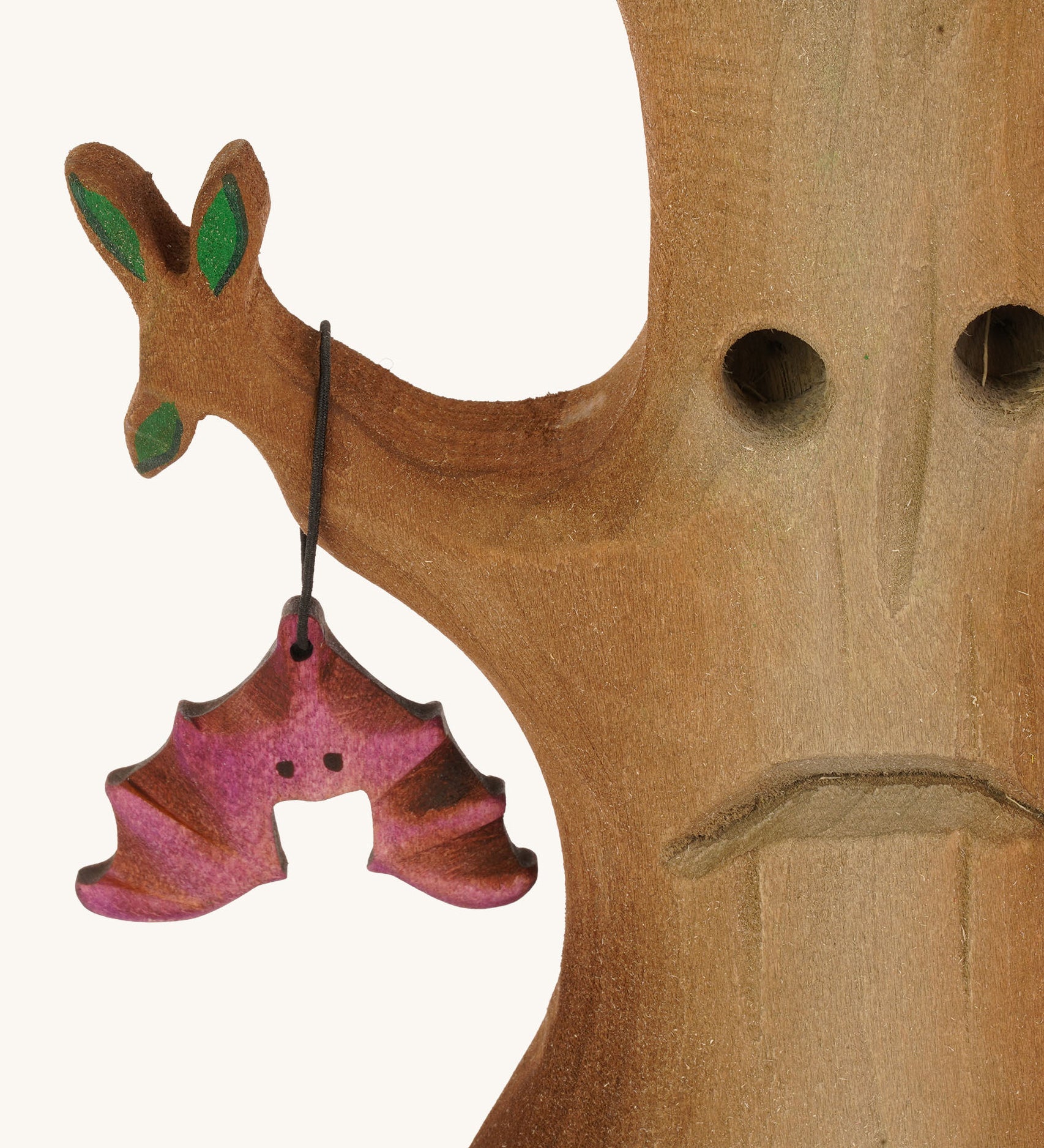 A close up of the Bumbu wooden hat figure on the Bumbu Halloween tree on a plain background