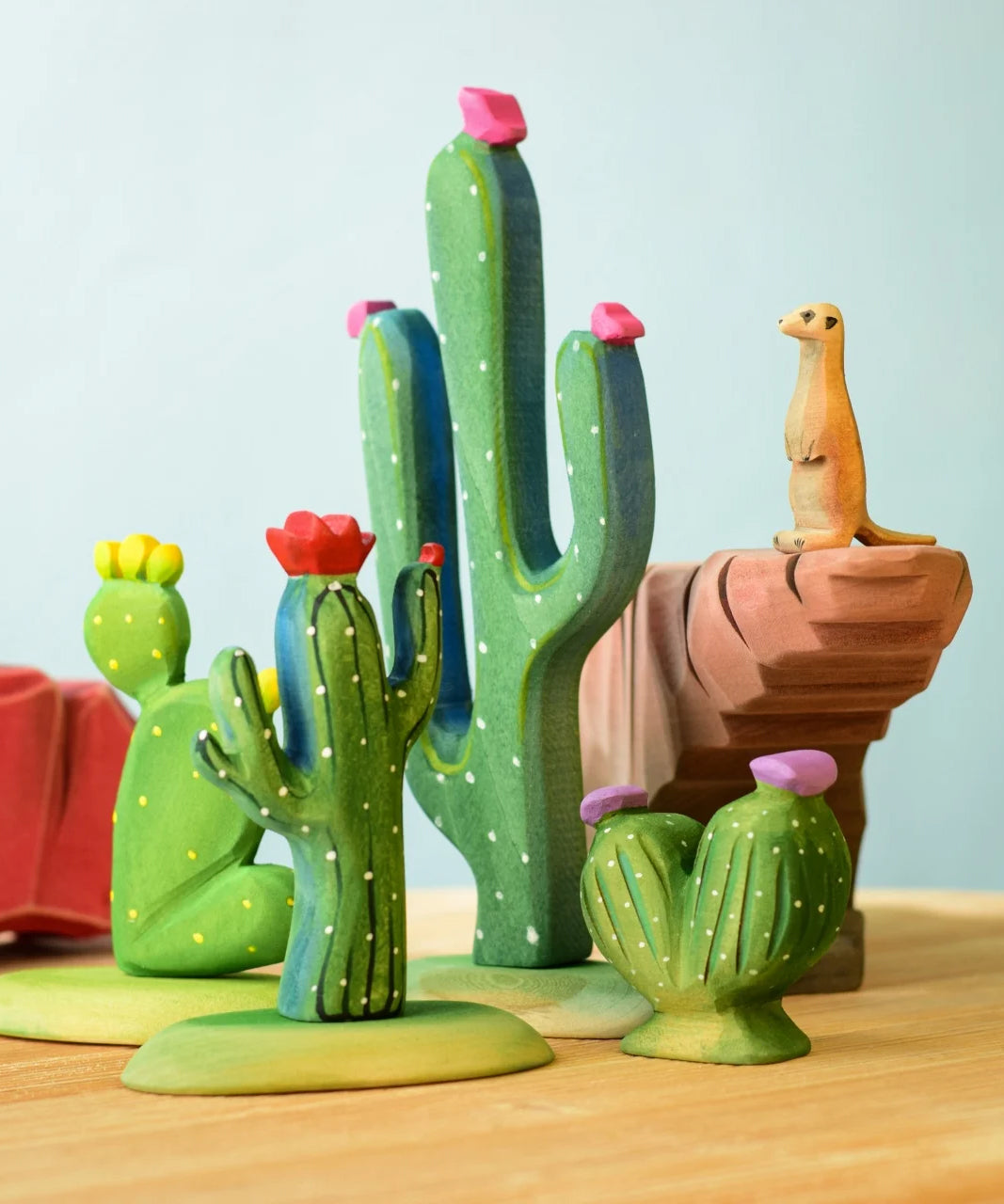 The Bumbu Wooden Saguaro Cactus Figure with red flowers in the foreground