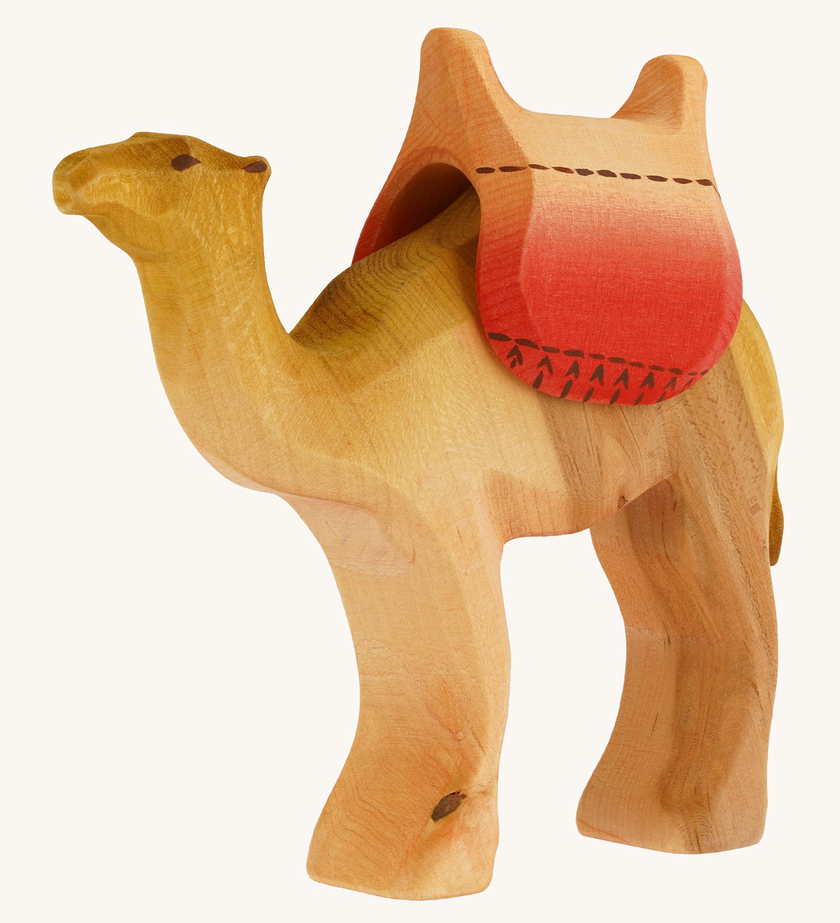 Bumbu wooden camel figure with saddle on a plain background.